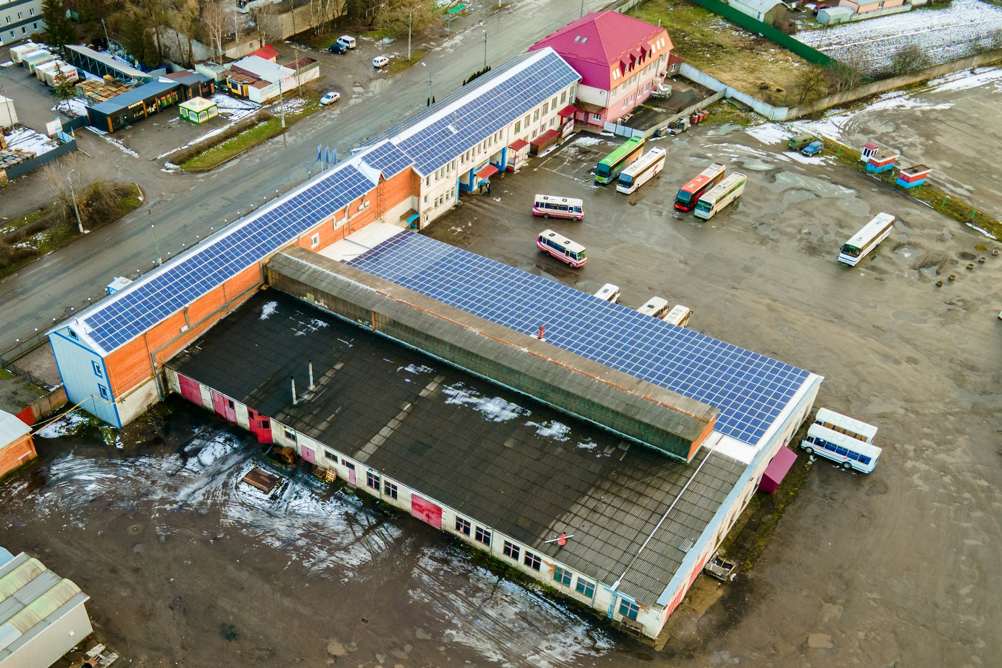 Blue photovoltaic solar panels mounted on industrial building roof for producing clean ecological